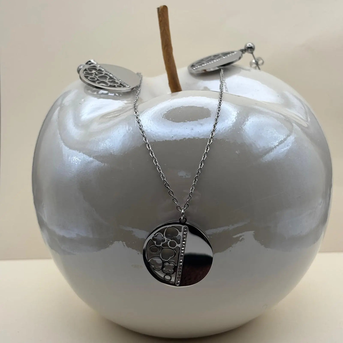 Boucles d'oreilles et pendentif argenté avec une pastille moitié plein moitié avec des motifs géométriques