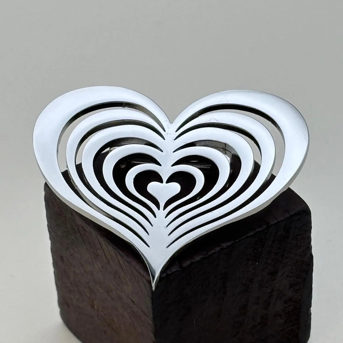 Broche argentée en forme de coeur ajouré 