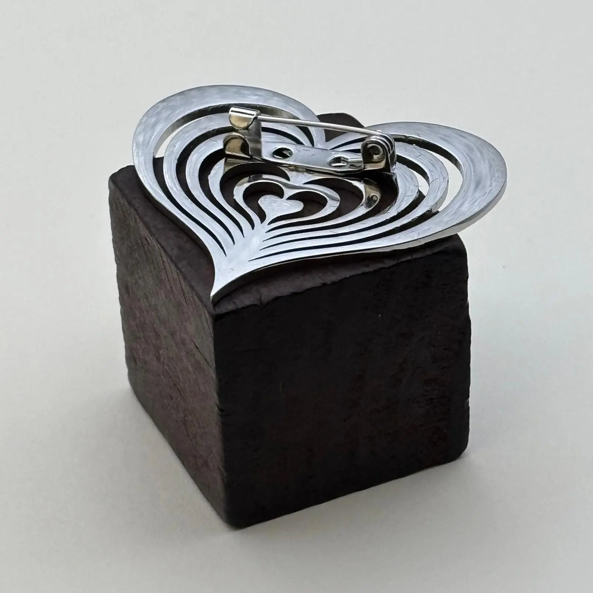 Broche de couleur argentée en forme de coeur ajouré 