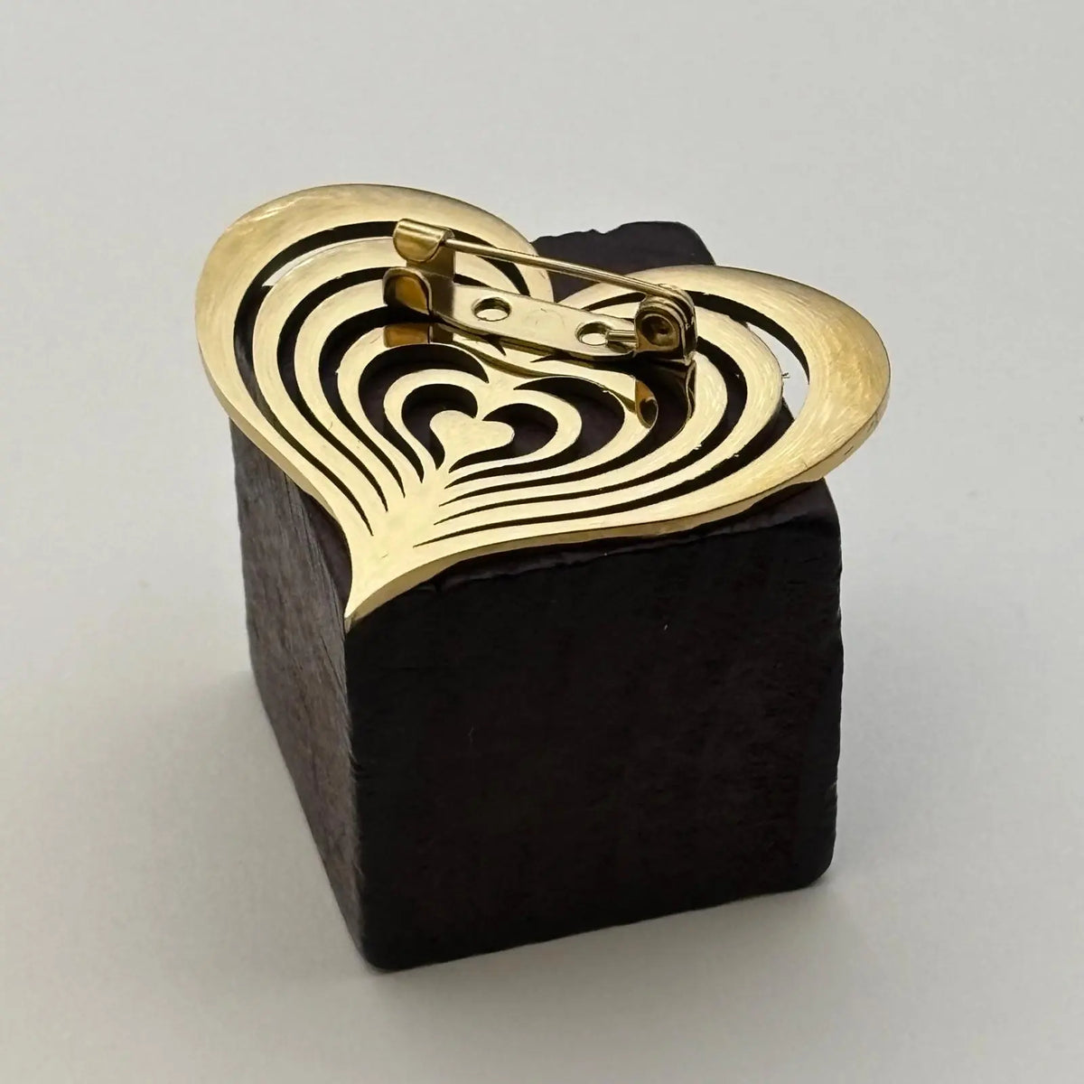 Broche de couleur dorée en forme de coeur ajouré 