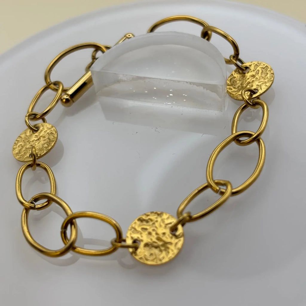 Bracelet de couleur dorée avec des anneaux dorés et médaillon avec un fermoir par barre