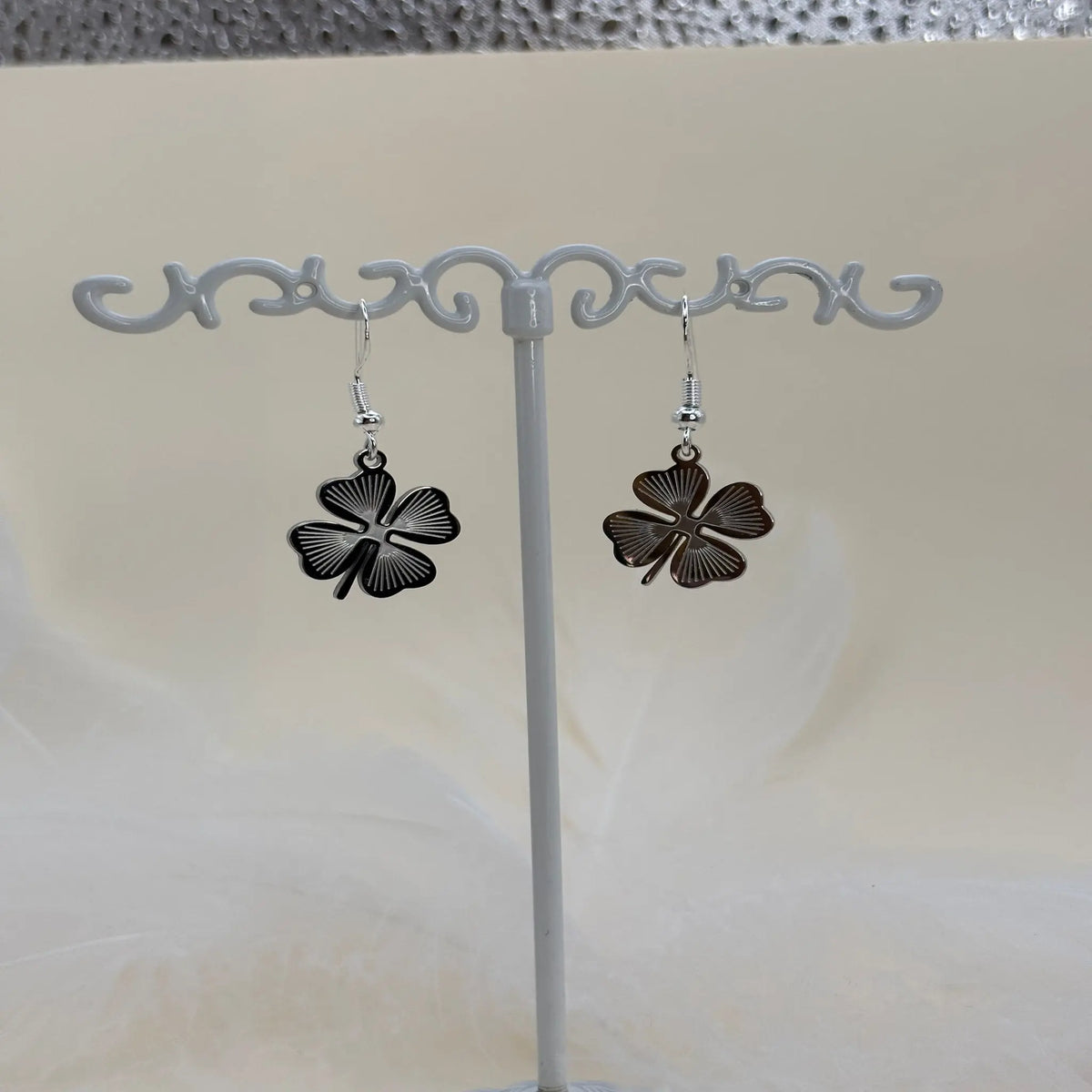Paire de boucles d'oreilles argentées avec un trèfle à quatre feuilles