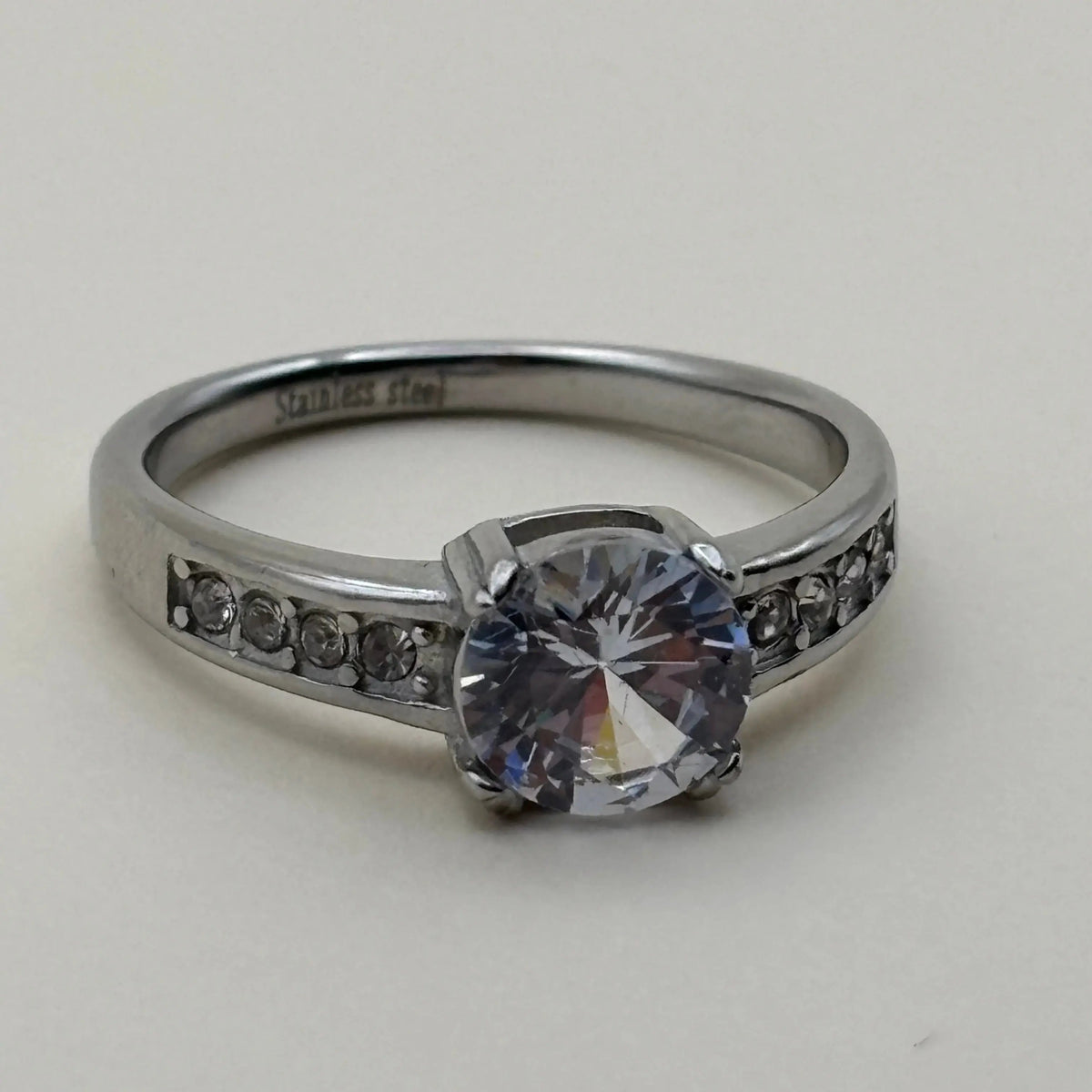 Une bague argentée avec strass en son centre  et sur les côtés