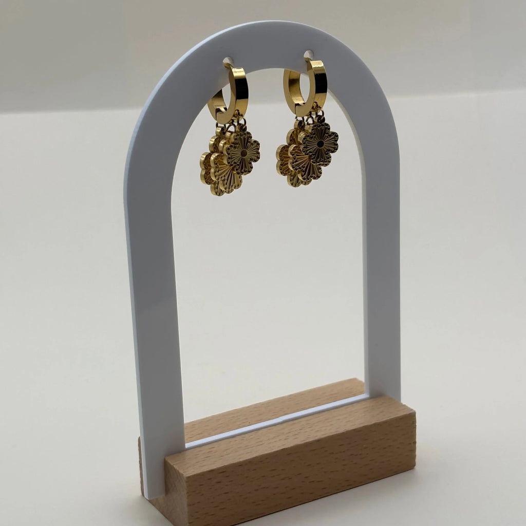 Des boucles d'oreilles dorées avec trois fleurs superposées