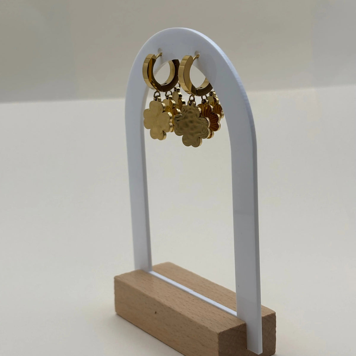 Une paire de boucles d'oreilles dorées avec trois fleurs superposées