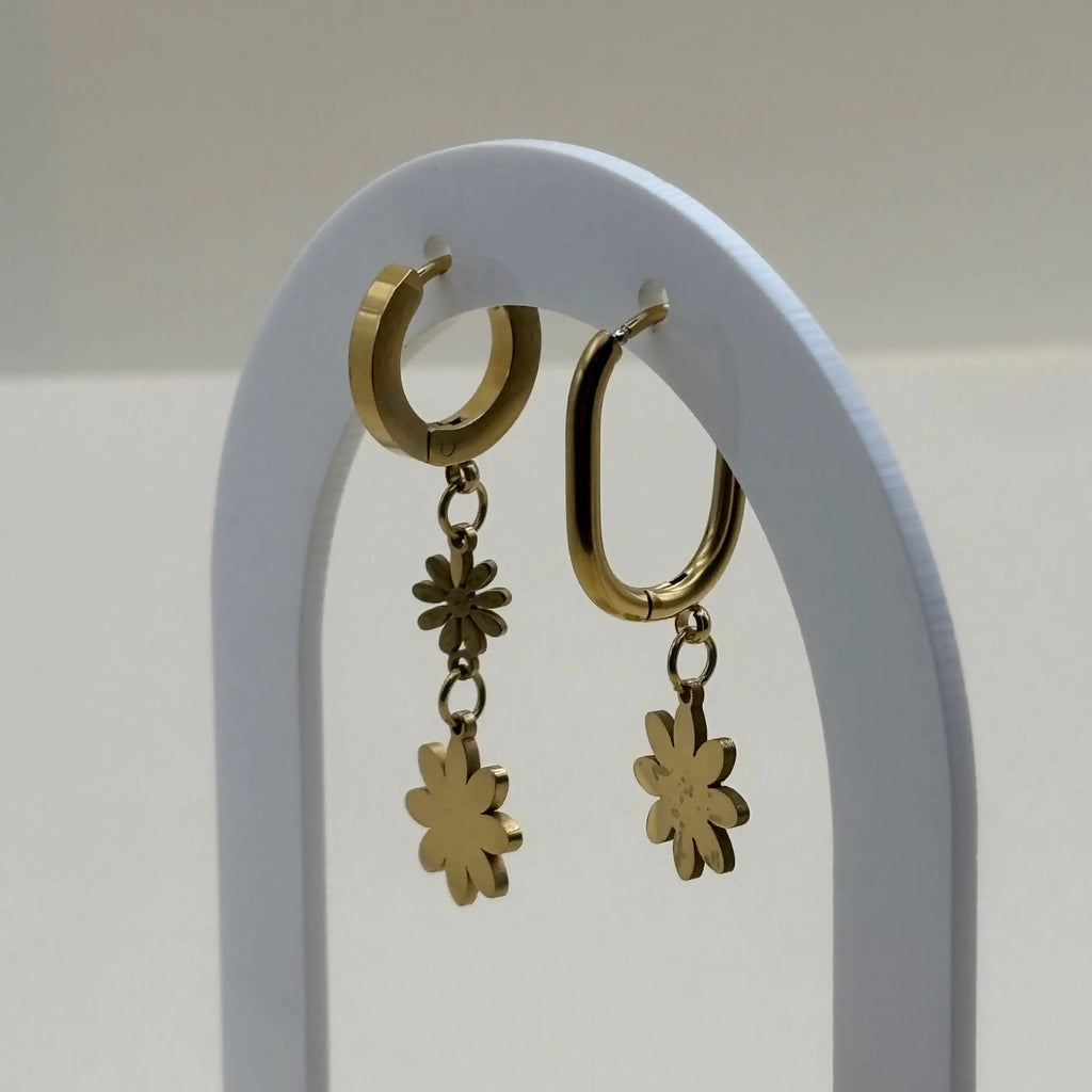 Des petites boucles d'oreilles asymétriques créoles avec marguerites blanches et orange