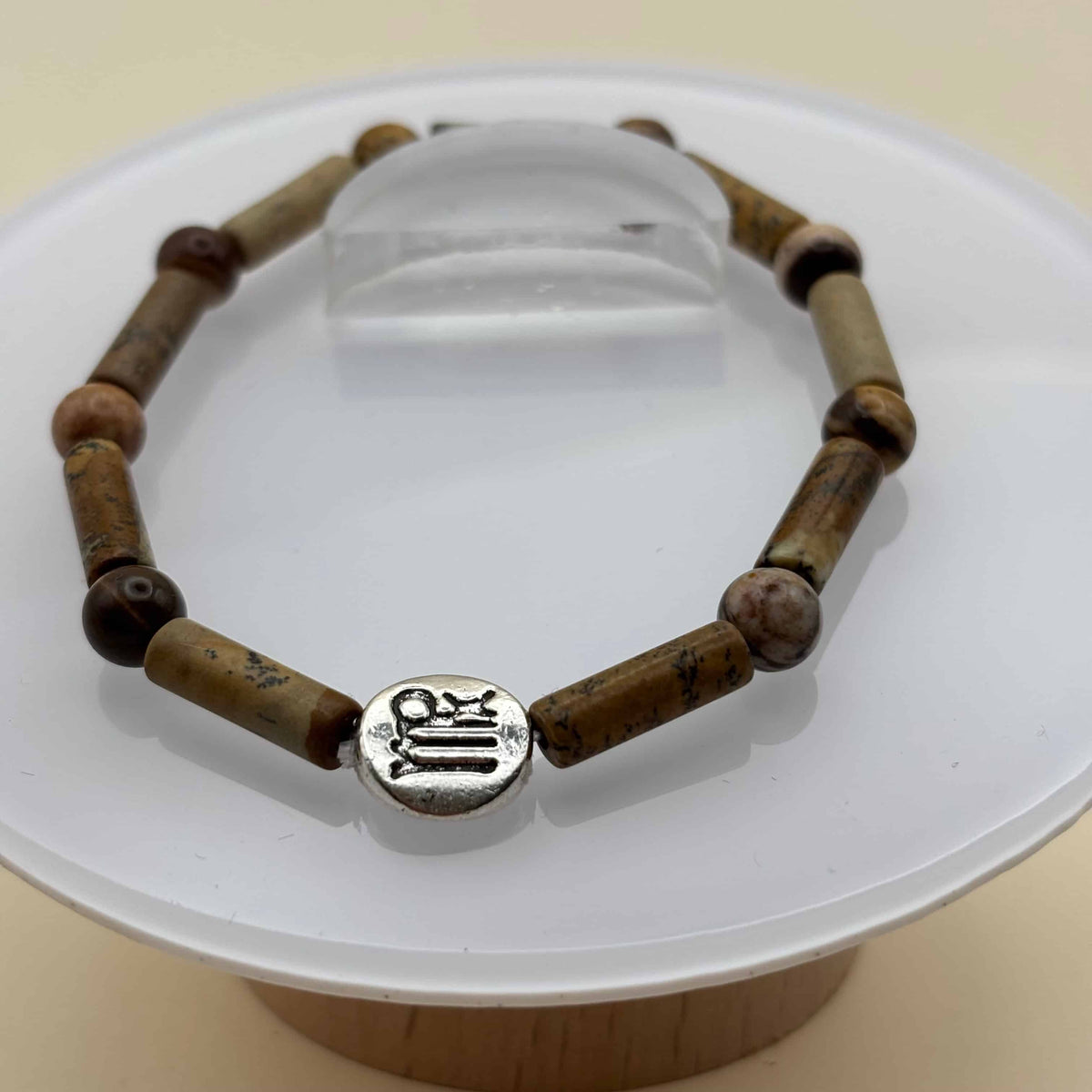 Un beau bracelet en perles sur élastique avec perles en porcelaine et en verre et médaillon avec le signe zodiacal de la vierge