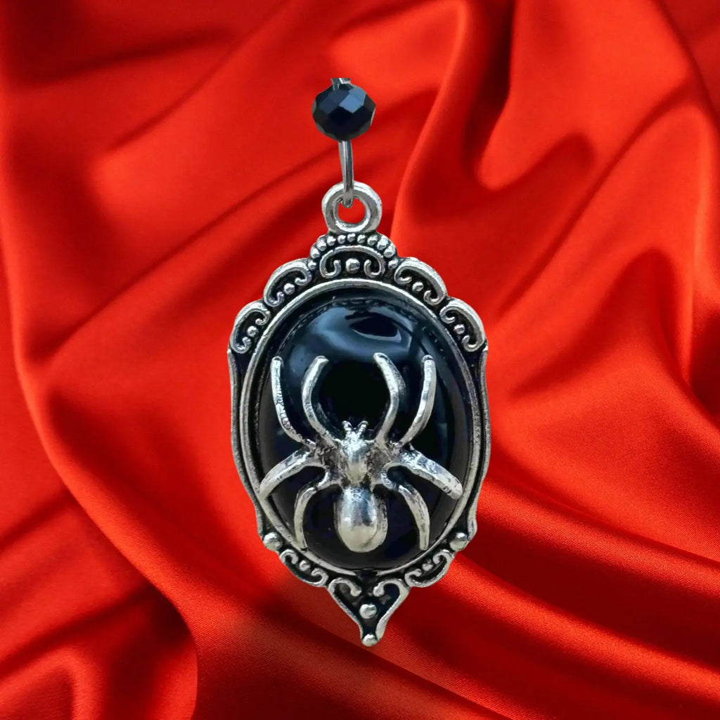 Boucles d'oreilles pendentif pour halloween en forme de médaillon argentée et fond noir et une grosse araignée dessus vendues sur le site pretes a briller