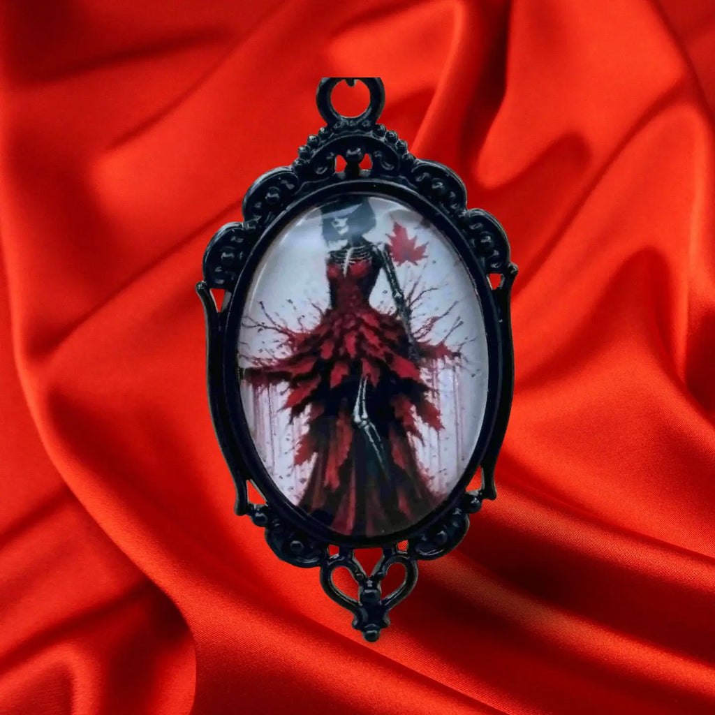 Boucles d'oreilles pour halloween en forme de médaillon noir avec à l'intérieur une femme en robe noire ornée de plumes rouges vendues sur le site pretes a briller