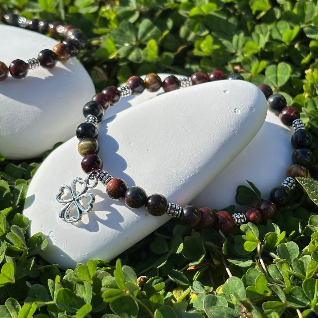 Un ensemble de deux bracelets artisanaux en perles oeil de tigre marbré et une breloque en forme de trèfle argenté