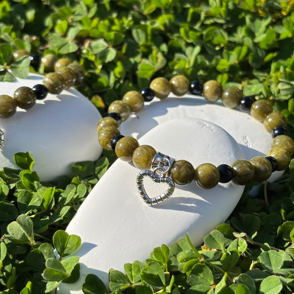 Un ensemble de deux bracelets artisanaux en perles de jaspe et obsidienne et une breloque en forme de coeur argenté