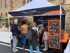 Un stand de vente de bijoux fantaisie sur un marché artisanal avec beaucoup de personnes devant Image