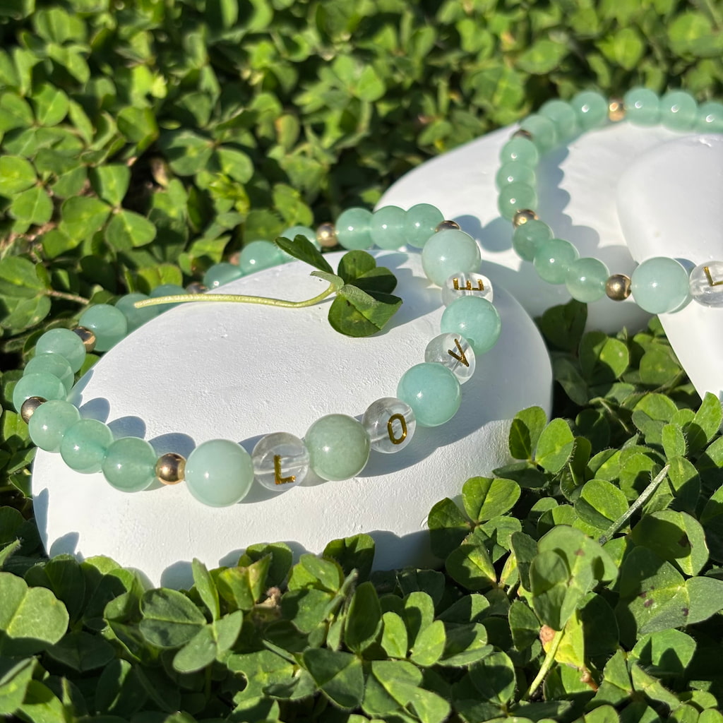 Vue de près d'un ensemble de deux bracelets artisanaux en perles d'amazonite et aventurine et une breloque et perles séparatrices