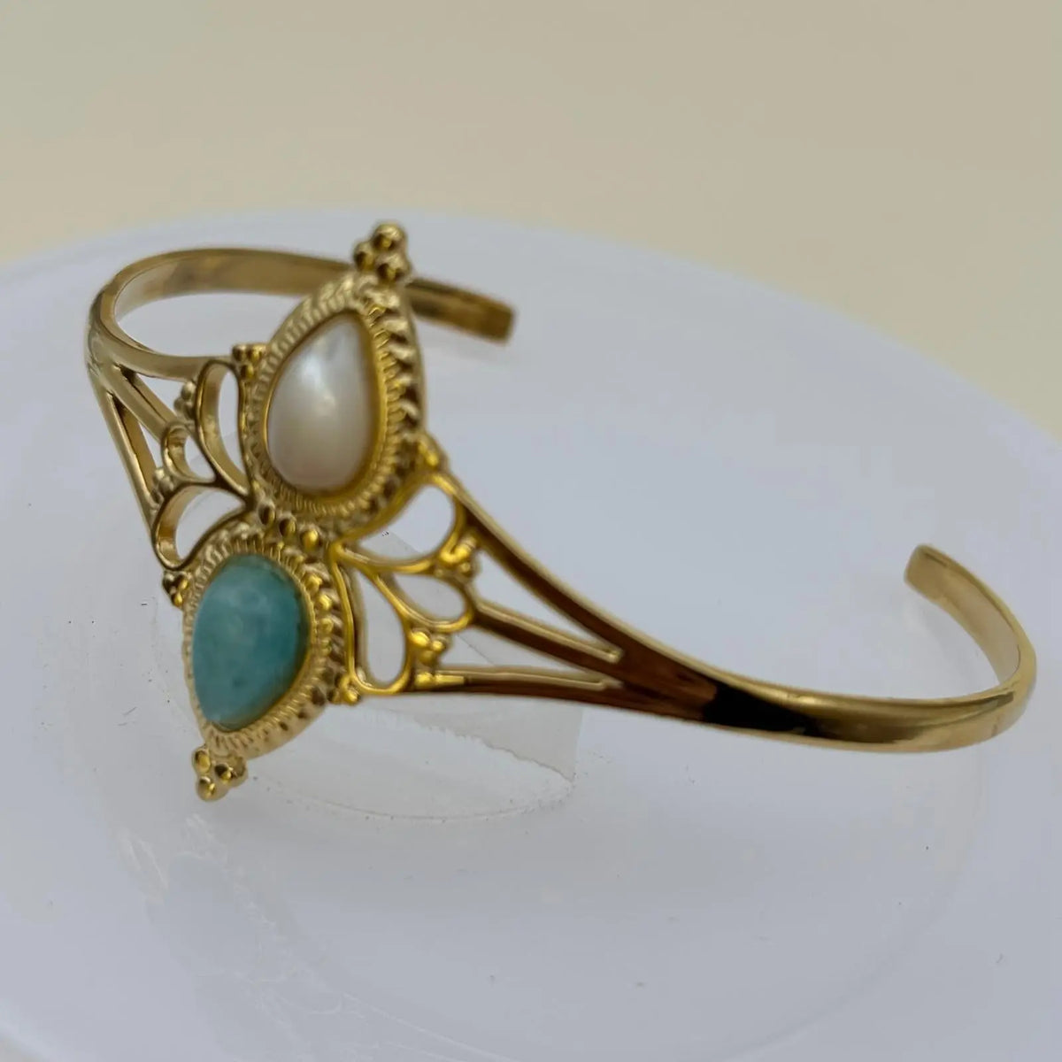 Bracelet doré rigide ouvert en acier inoxydable avec deux pierres blanche et turquoise