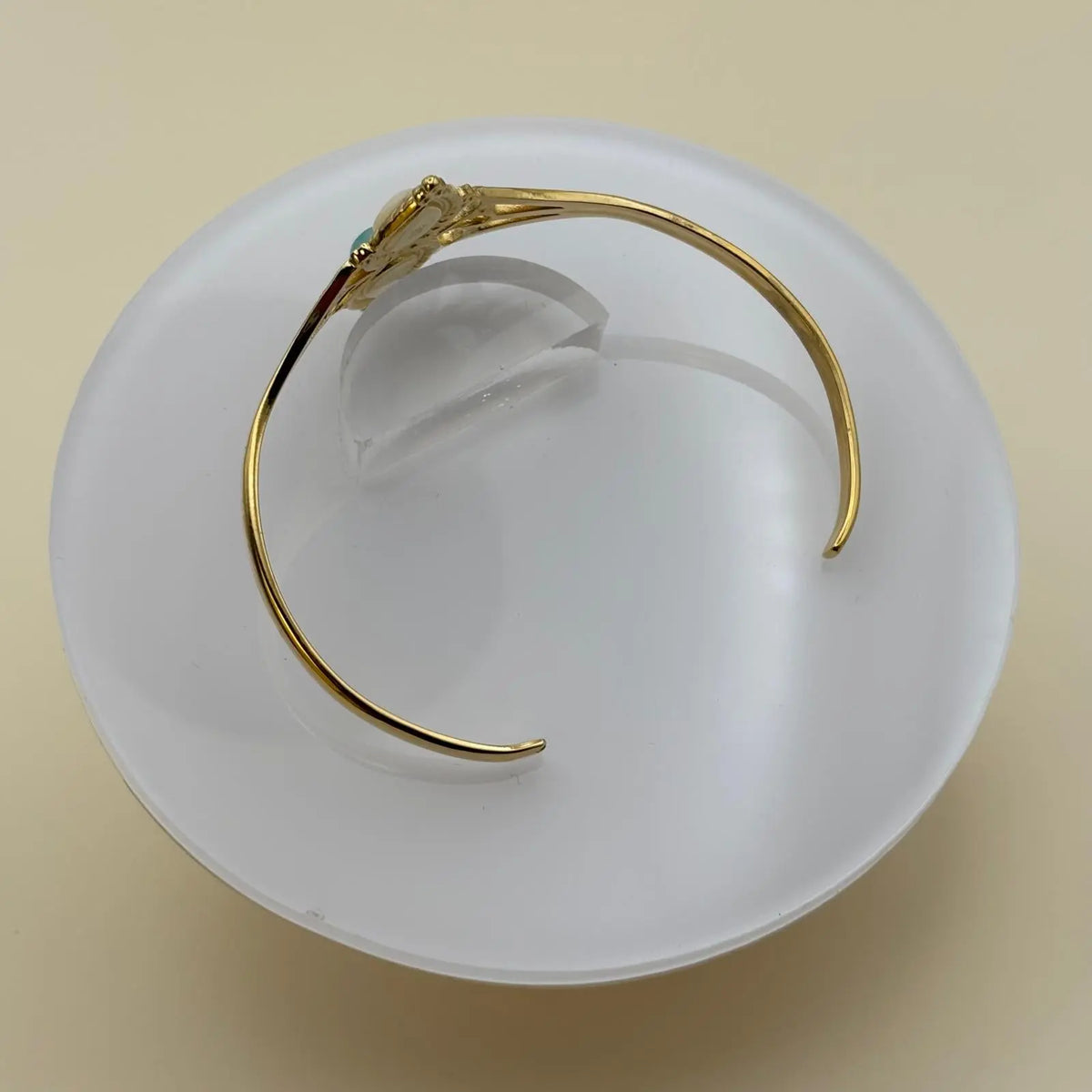 Bracelet doré rigide ouvert en acier inoxydable avec deux pierres l'une blanche et l'autre turquoise