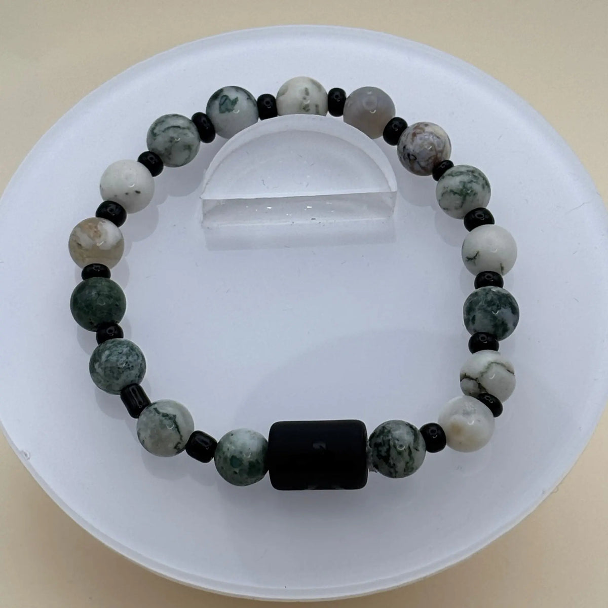 Bracelet associant perles rondes blanches et vert foncé avec un cylindre noir gravé en avant