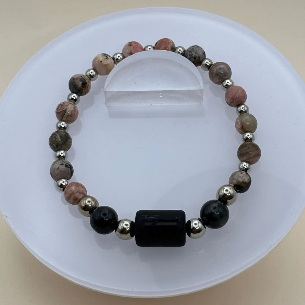 Bracelet alternant perles rosées marbrées et perles argentées avec un cylindre noir gravé