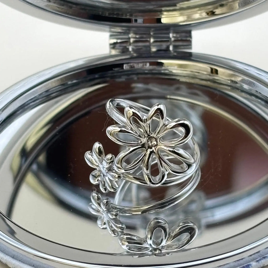 Bague argentée ajustable avec un motif de fleurs avec sept pétales entrelacées