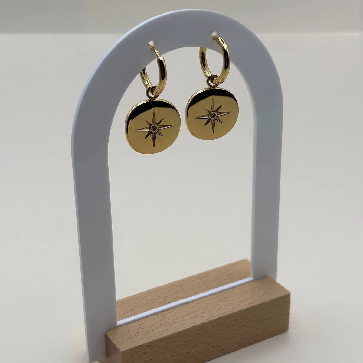 Mini créole et pendentif avec pastille dorée gravée d'une rose des vents en acier inoxydable