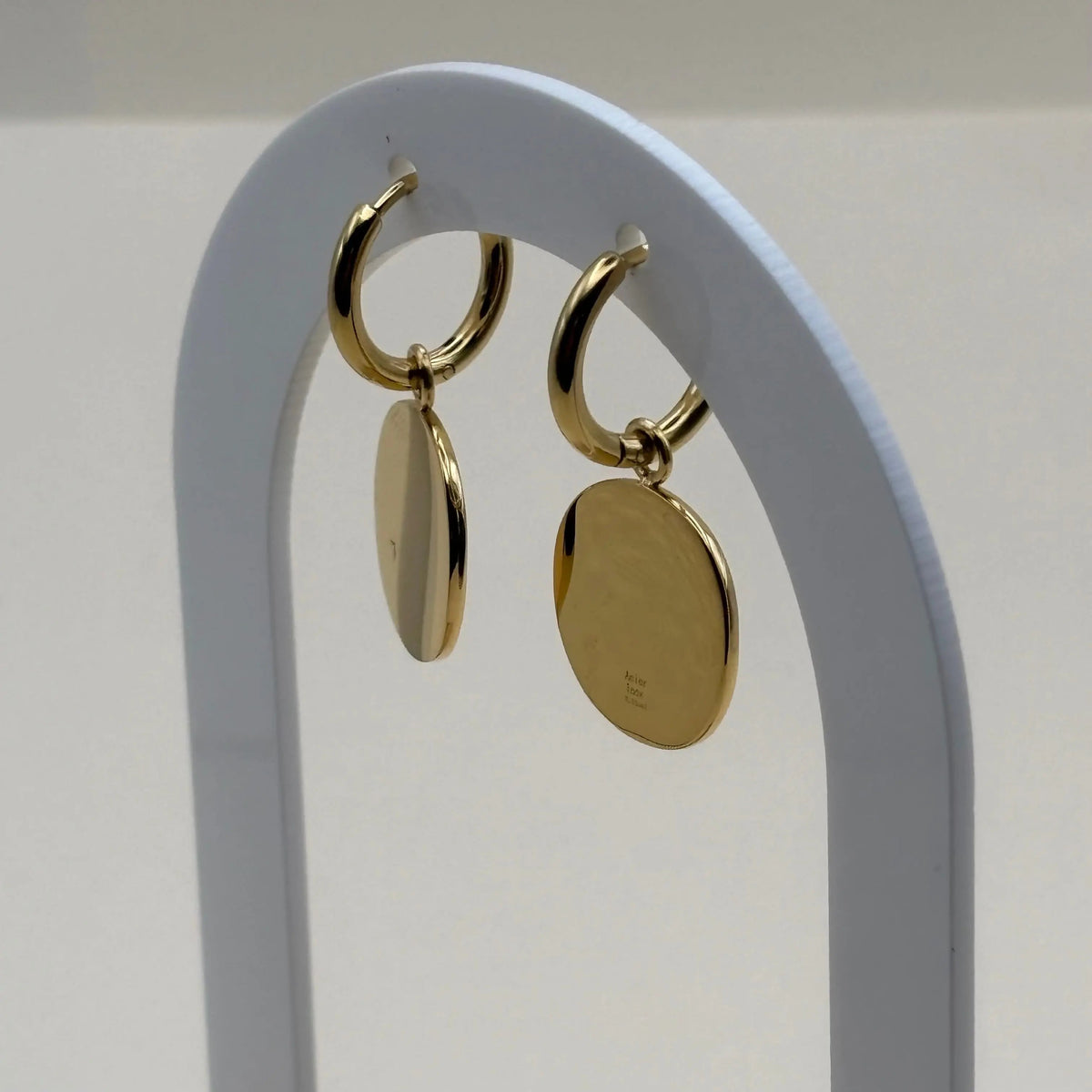 Mini créole et un pendentif avec pastille dorée gravée d'une rose des vents en acier inoxydable