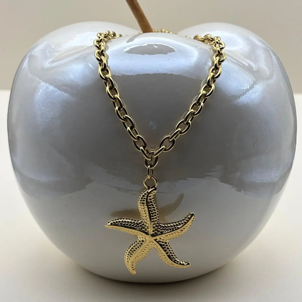 Vue de près d'un collier doré pendentif en forme d'étoile de mer en acier inoxydable