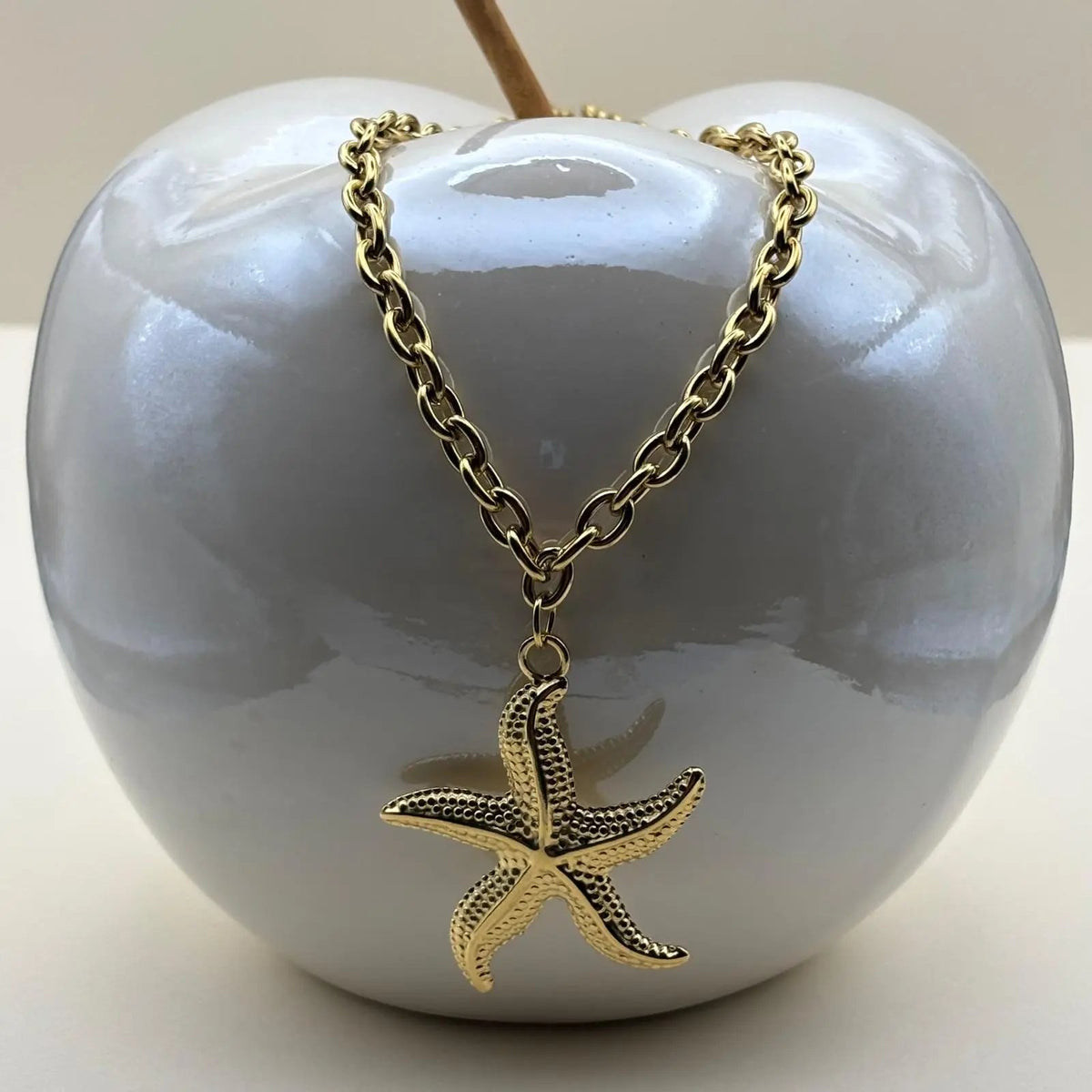 Vue de près d'un collier doré pendentif en forme d'étoile de mer en acier inoxydable