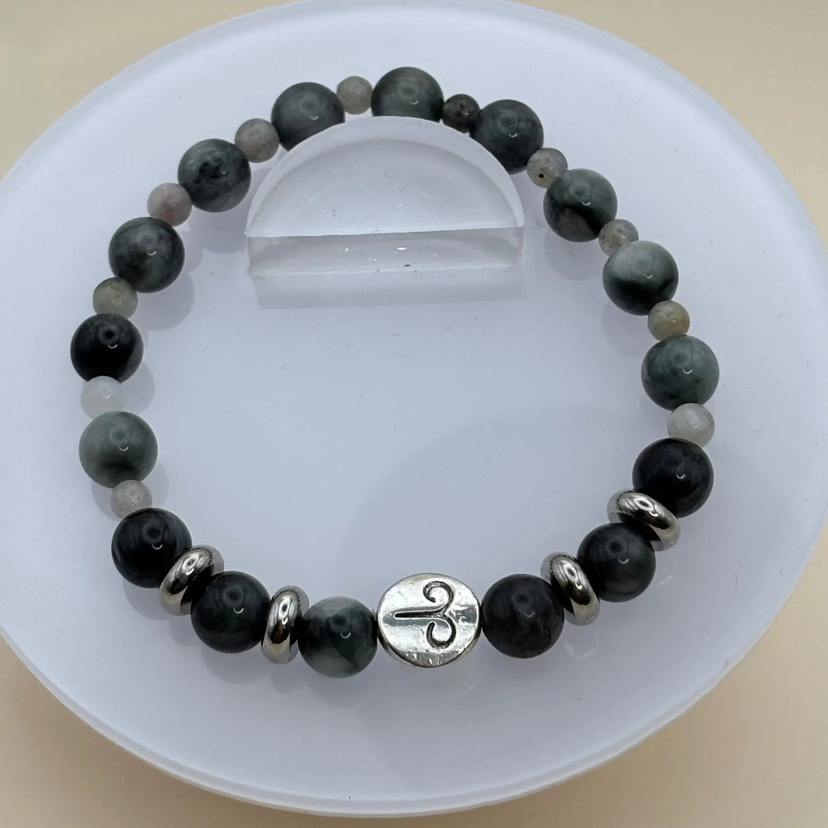 Bracelet de perles gris foncé et argent agrémenté d’un médaillon argenté gravé placé à l’avant