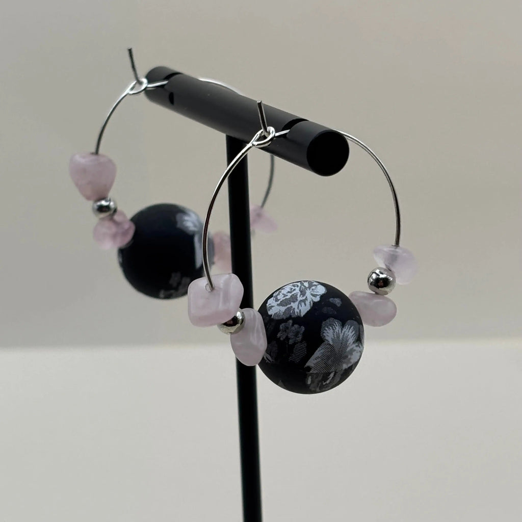 Une paire de boucles d'oreilles créoles avec pendentifs marbrés et pierres roses 