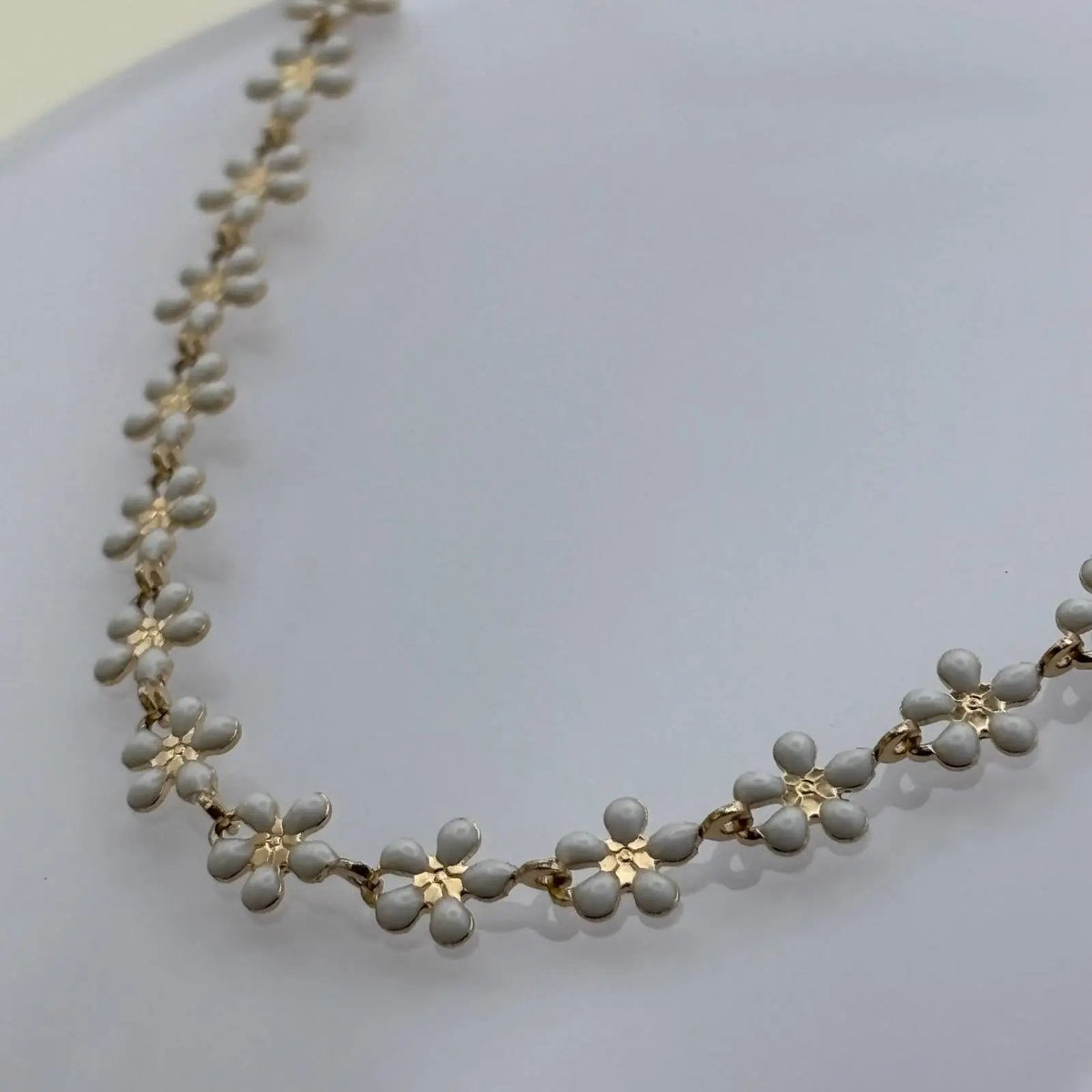 Bracelet de cheville avec des fleurs marguerite dorées peintes en pointe de céramique blanche