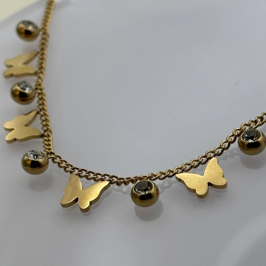 Bracelet de cheville avec chainette dorée et breloques papillons et brillants 
