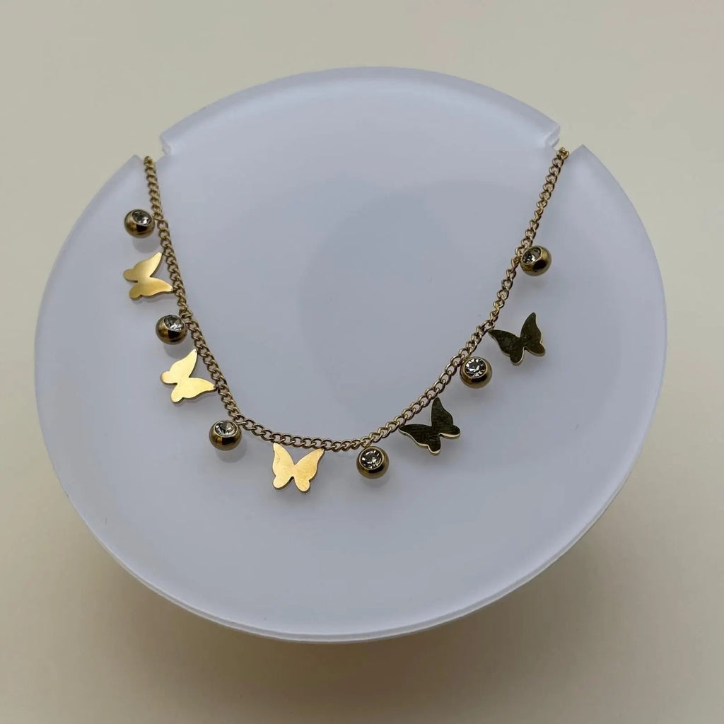 Bracelet de cheville avec une chainette dorée et breloques papillons et brillants 