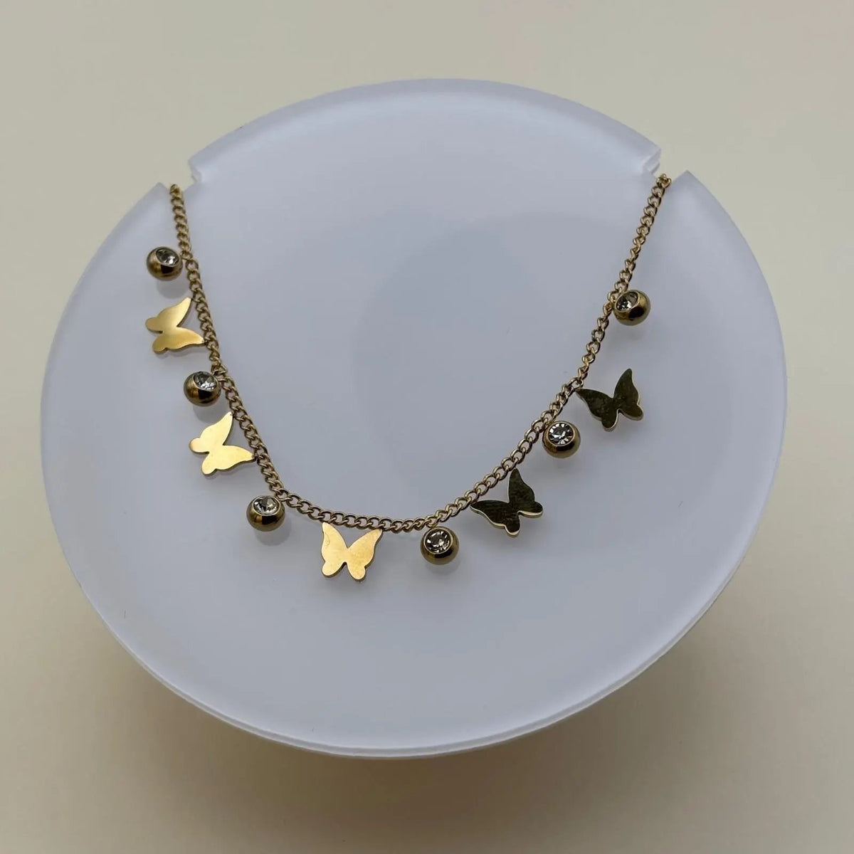 Bracelet de cheville avec une chainette dorée et breloques papillons et brillants 