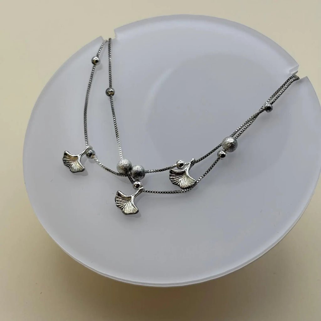 Bracelet de cheville avec des breloques en forme de feuilles et de perles