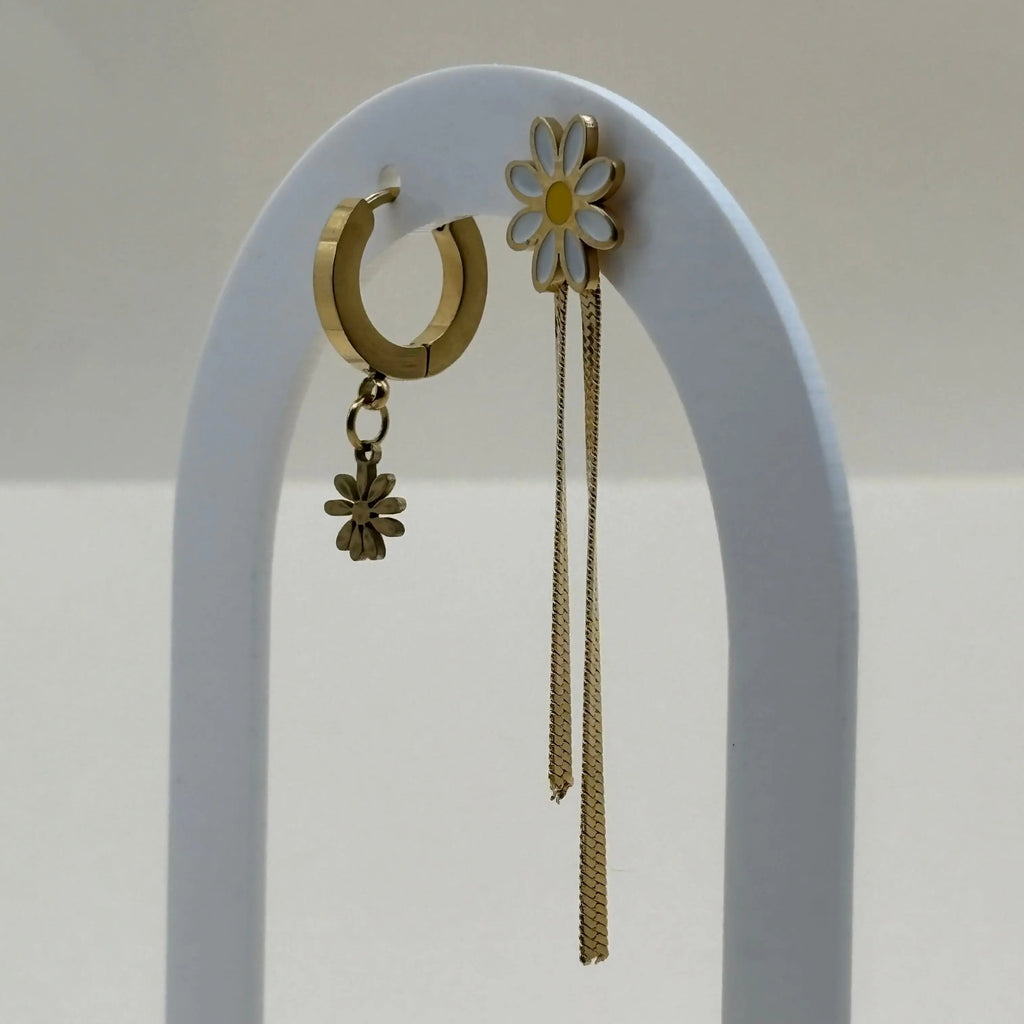 Des boucles d'oreilles dorées avec breloque marguerite