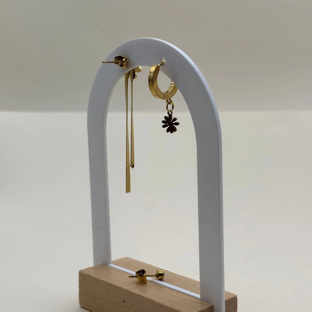 Une paire de boucles d'oreilles dorées avec breloque marguerite