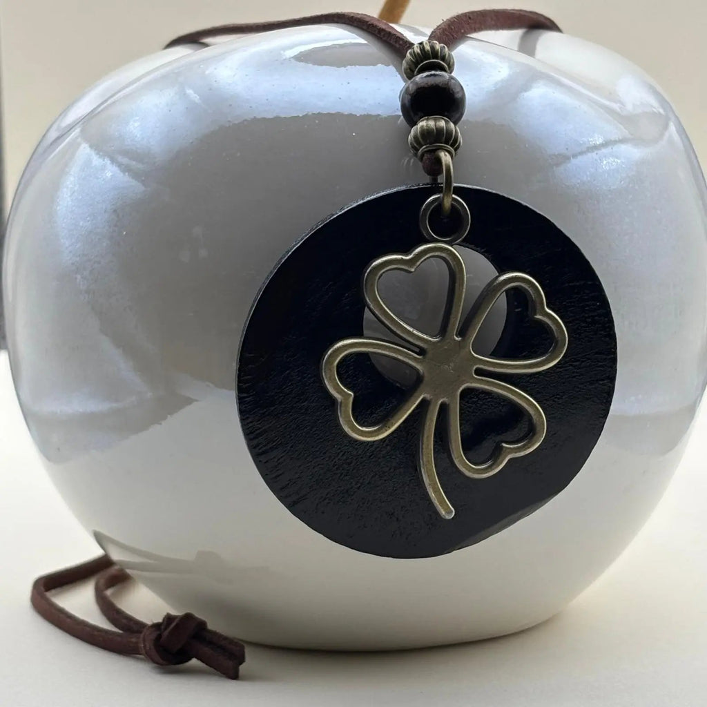 Collier fantaisie en médaillon en bois marron motif porte bonheur trèfle et cordon en cuir