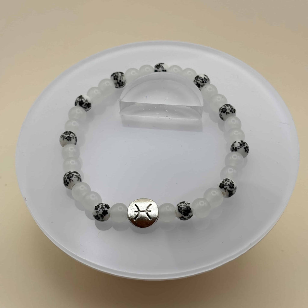 Un bracelet artisanal en pierres naturelles avec le signe zodiacal du poisson
