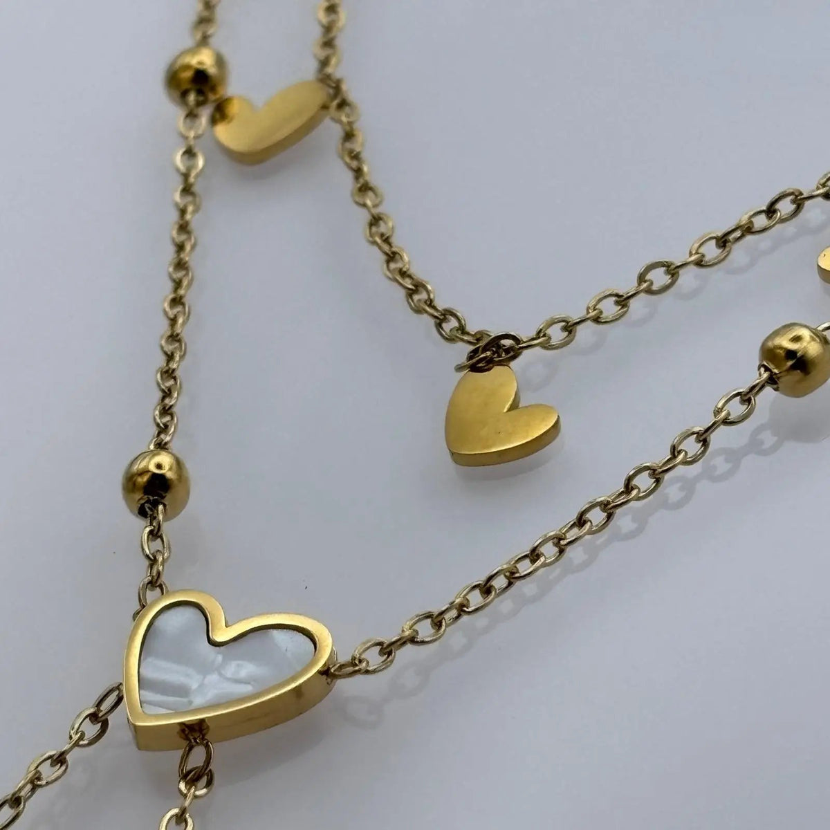 Bracelet de cheville avec chainette dorée et des breloques coeur blanc