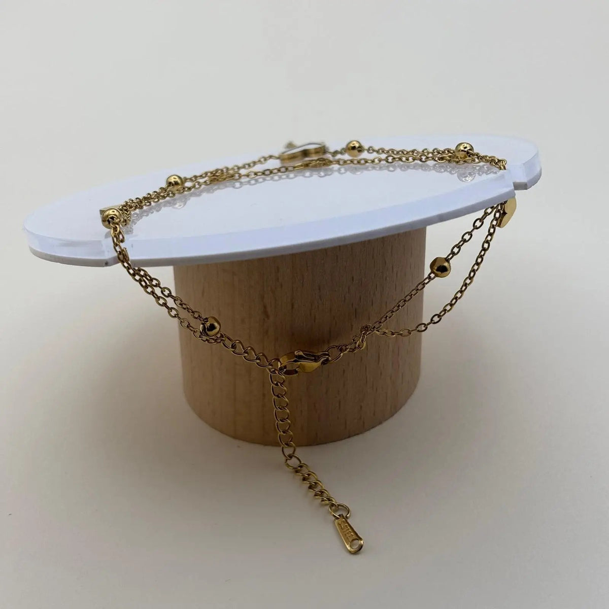 Bracelet de cheville avec chainette dorée et des breloques un coeur blanc