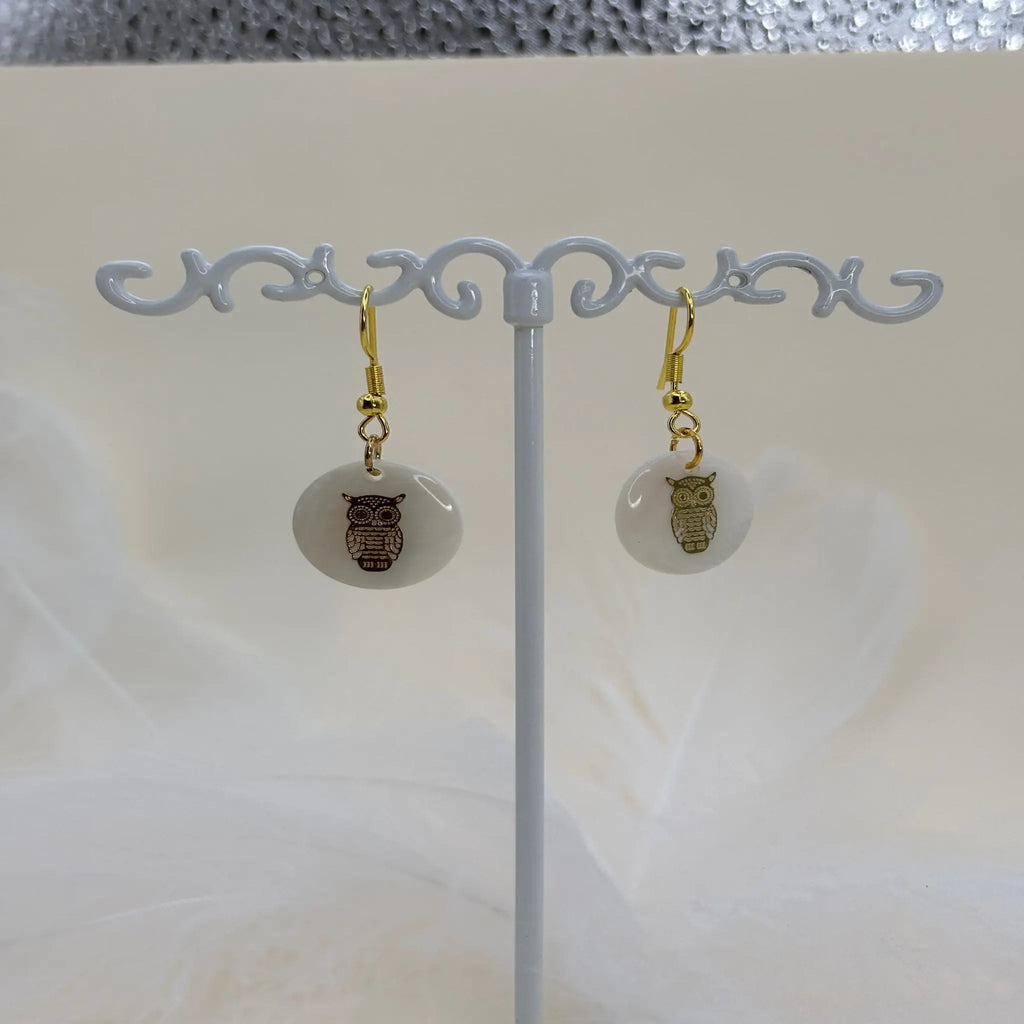 Paire de boucles d'oreilles avec une pastille nacrée et dessin d'un hibou