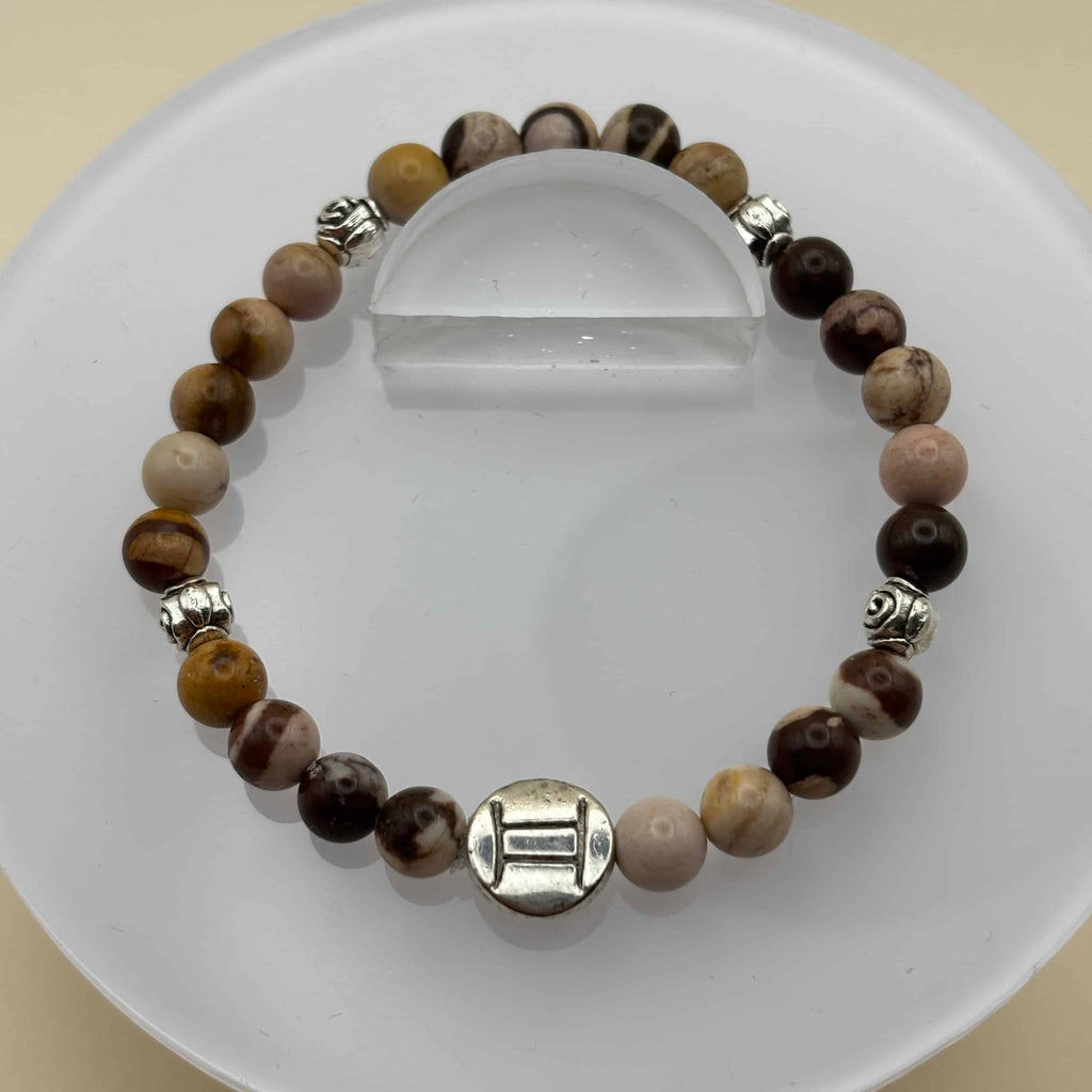 Un beau bracelet en perles sur élastique avec perles en porcelaine et en verre et médaillon avec le signe du gémeaux