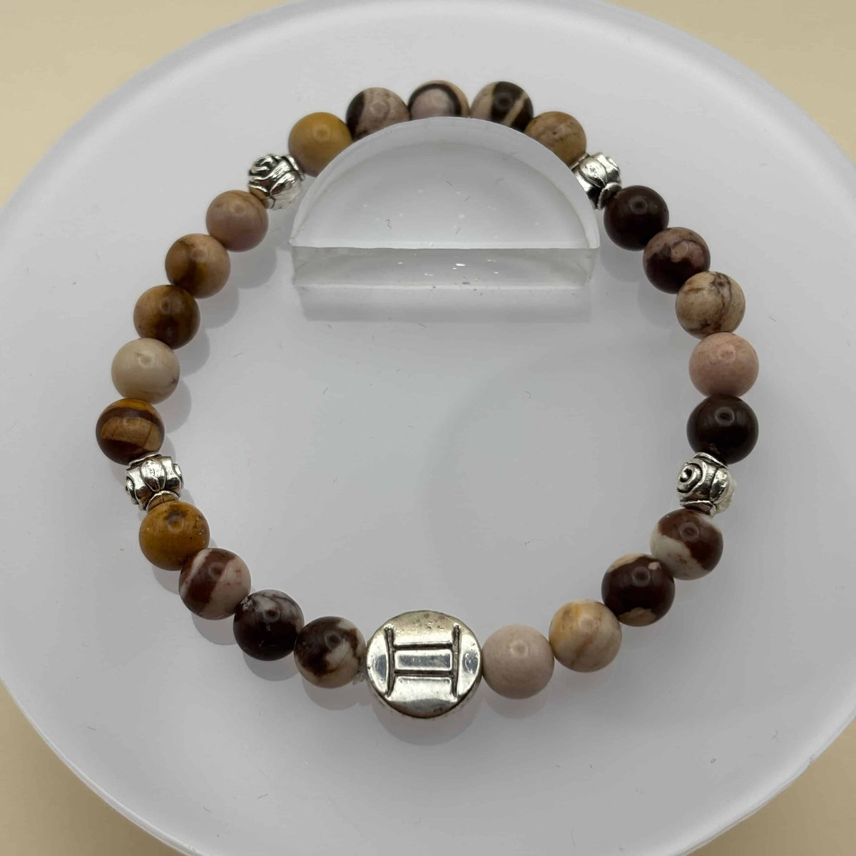 Un beau bracelet en perles sur élastique avec perles en porcelaine et en verre et médaillon avec le signe du gémeaux