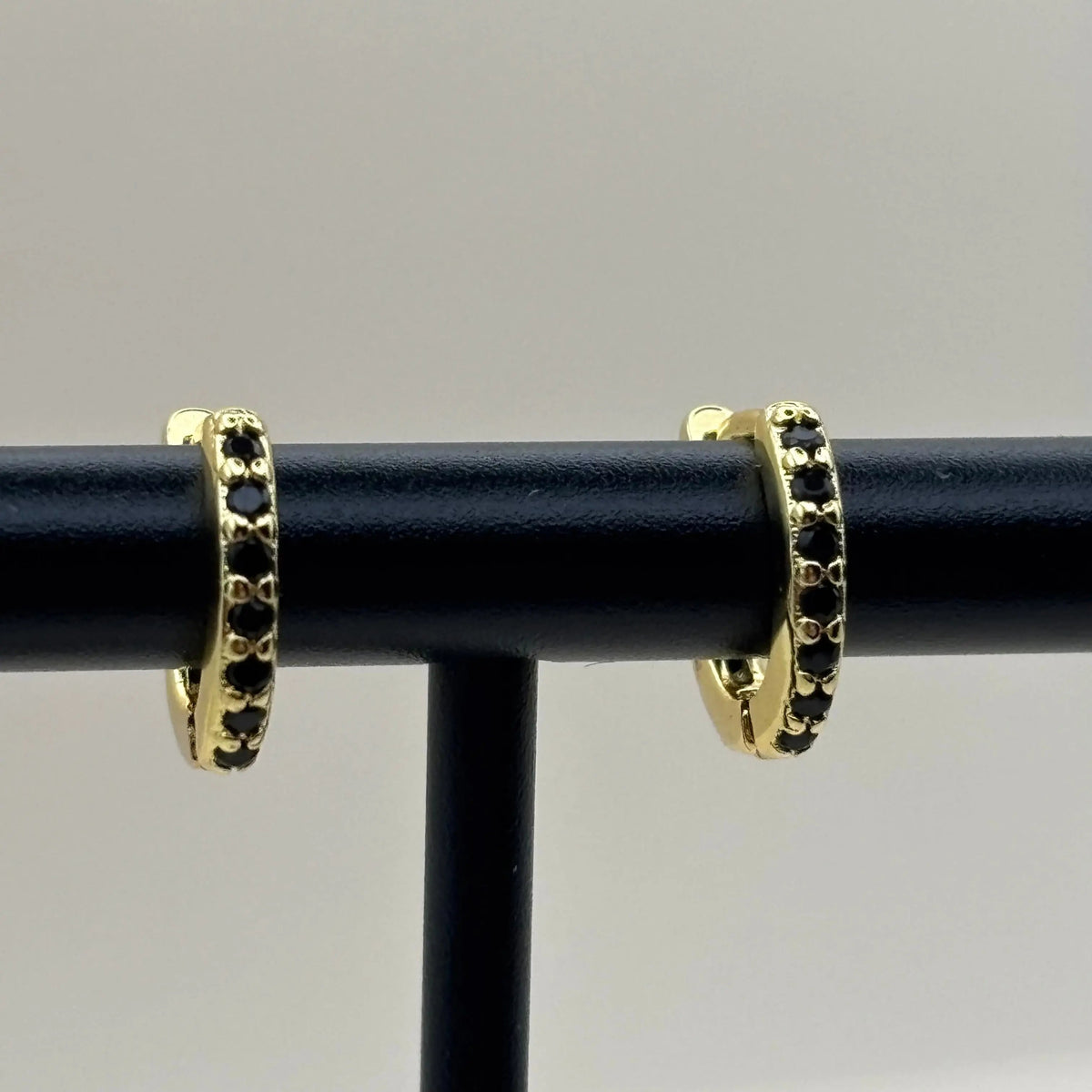 Piercing de nez en plaqué or 18 carats, orné de zircons noirs.