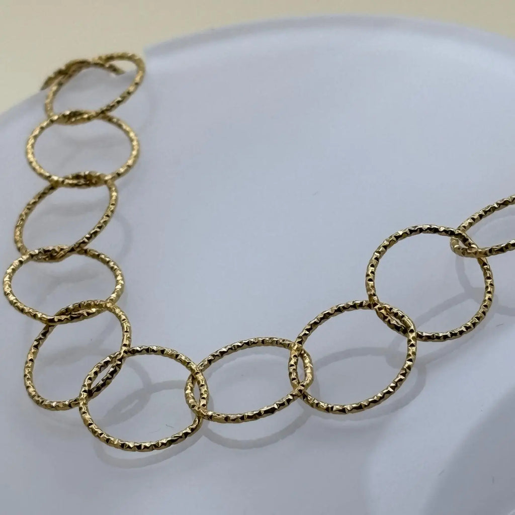 Bracelet doré avec des anneaux dorés et médaillon avec un fermoir par barre 