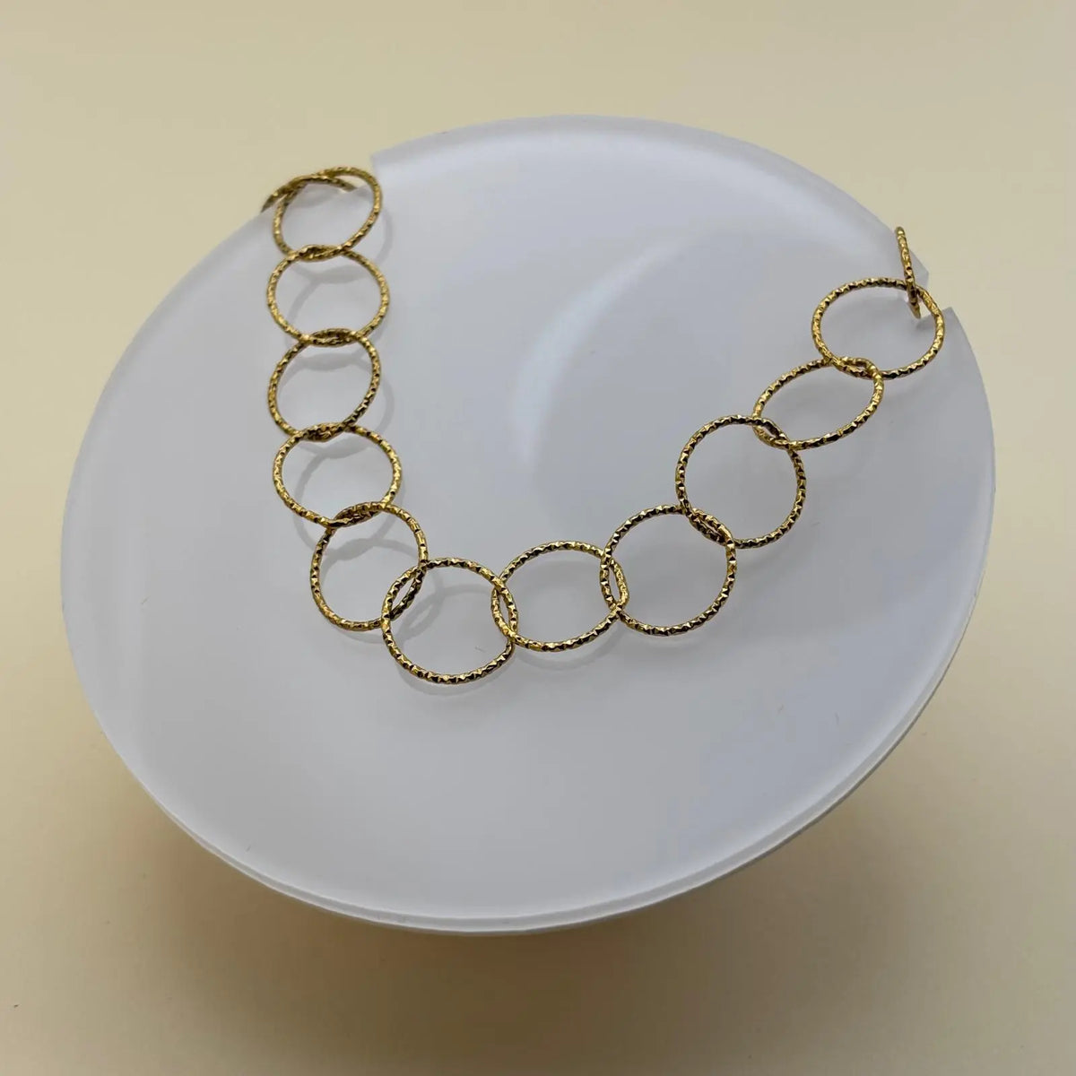 Bracelet de couleur dorée avec des anneaux dorés et médaillon avec un fermoir par barre