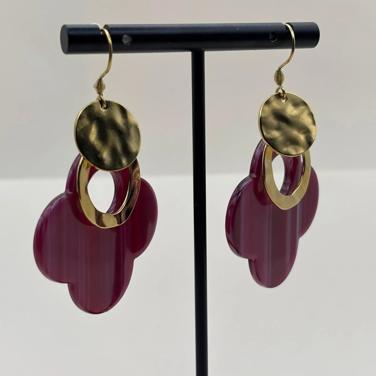 Des boucles d'oreilles dorées avec fleur stylisée en résine mauve et anneaux dorés