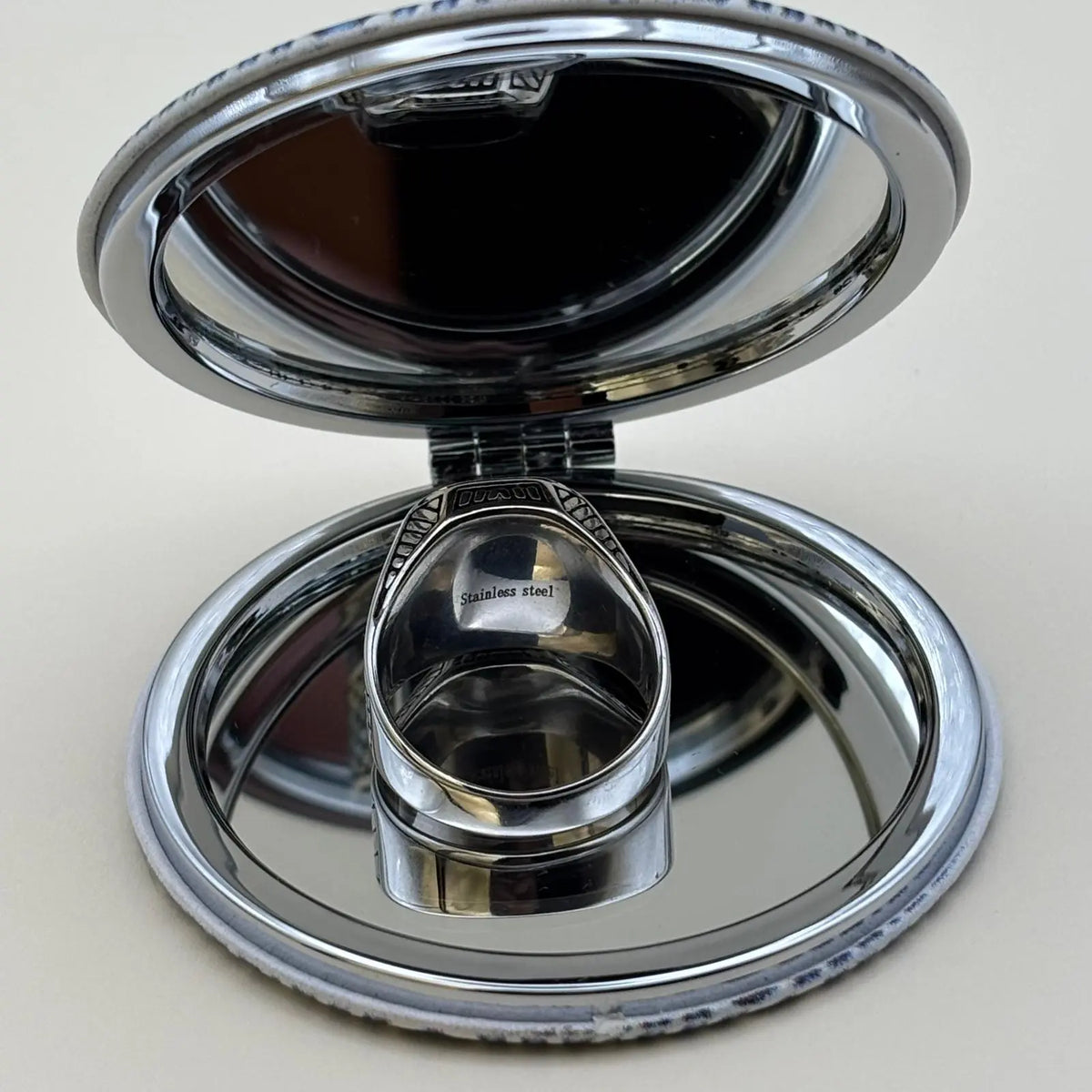 Vue de derrière d'une chevalière argenté avec face en noir brillant et contour ciselé