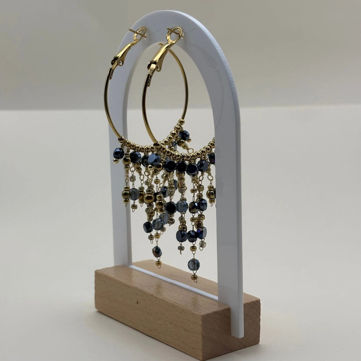 Une paire de boucles d'oreilles créoles dorées avec breloques perles de verre bleues en acier inoxydable