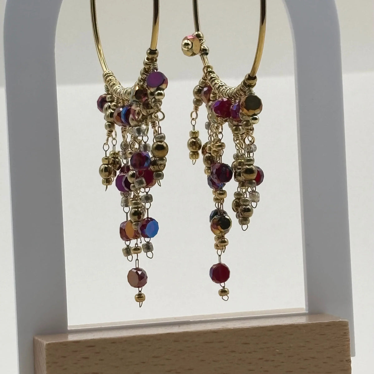 Des boucles d'oreilles créoles dorées avec breloques perles de verre rouges en acier inoxydable