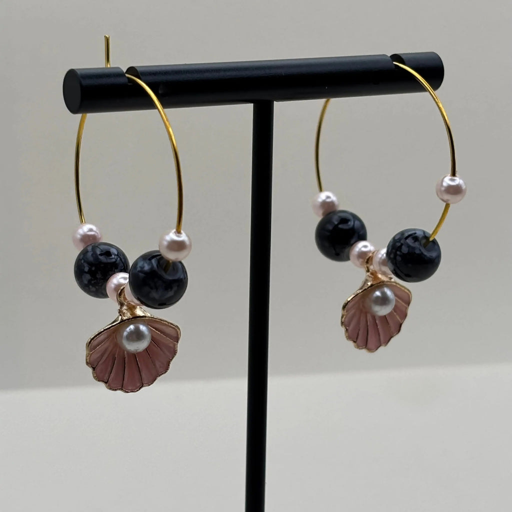 Des boucles d'oreilles créoles dorées avec breloque coquille Saint jacques rose et perles